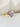 Natural powder blush sapphire engagement ring in 14k yellow gold with a 2.7ct oval sapphire and botanical diamond setting.