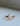 Gold ring with a large pear cut diamond center, supported by moth wings made of carved gold and encrusted with smaller diamonds on the edges