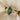 Fiore Alpha + Beta 2ct marquise green lab diamond engagement ring in 14k yellow gold, with hummingbird-inspired details and lab diamond accents, on ivory silk.